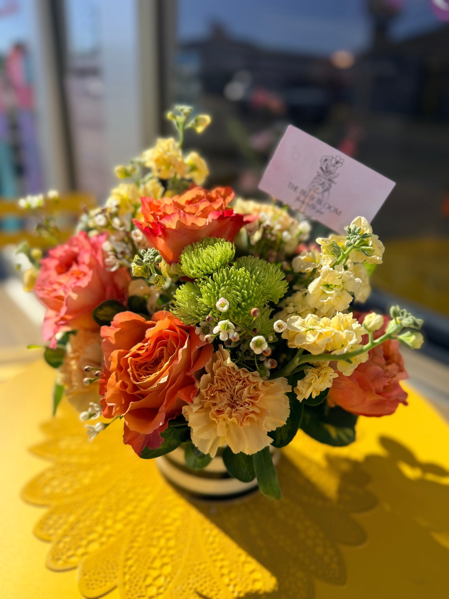 Colorful flower arrangement on a yellow table with a blurred background